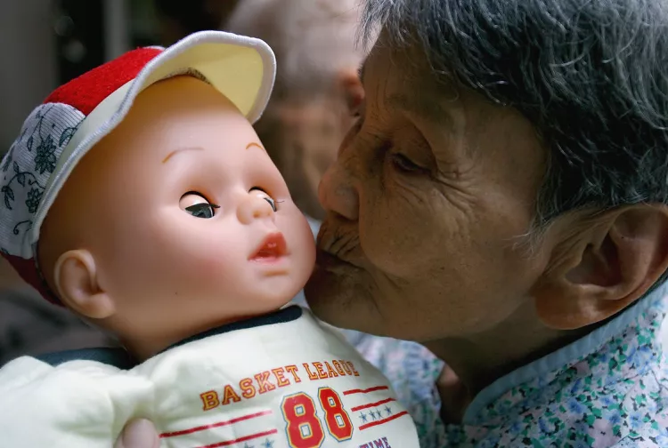 chinese old women with little doll for her doll therapy